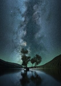 It's all your money: fundraising and non-duality--oneness--go together in the oneness of the Universer in a beautiful dark sky illuminated by the Milky Way with river reflecting trees at the horizon